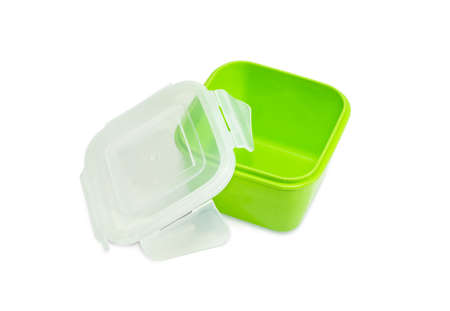 Green reusable plastic food storage container for home use with open translucent cover on a light backgroundの写真素材