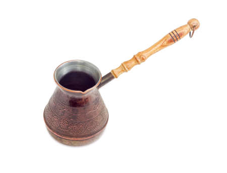 Empty old copper coffee pot with a wooden handle on a light backgroundの写真素材