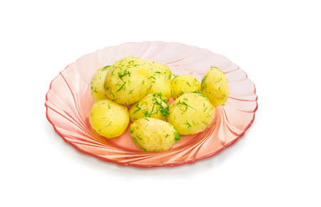 Boiled whole young potatoes of  early ripening with a butter, sprinkle with the chopped dill on the pink glass dish on a light backgroundの写真素材