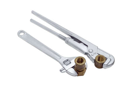 Plumber wrench and adjustable wrench with silvery coating and brass plumbing screw-nut with coupling and pipe coupling on a light backgroundの写真素材