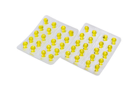 Two blister packs with a pharmaceutical drug in the form of yellow pills on a light backgroundの写真素材