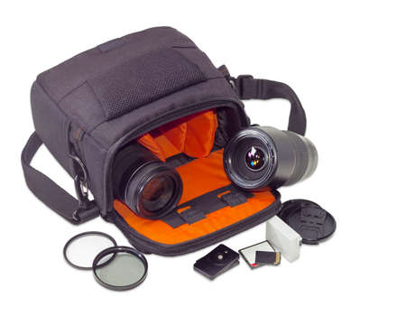 Two different photo lenses in the open camera bag and some other photo accessories beside on a light backgroundの写真素材