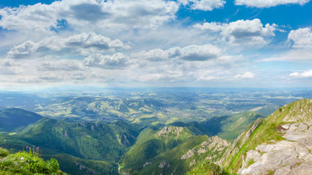 View from the mountain of the spurs of the mountain range, valley and mountain town on the background of the sky with clouds in the Tatra Mountainsの写真素材