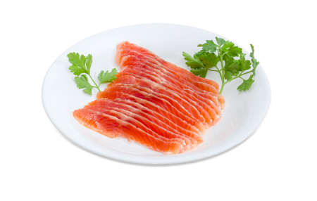 Sliced fillet of salted rainbow trout and twig of parsley on the white dish on a light background 
の写真素材