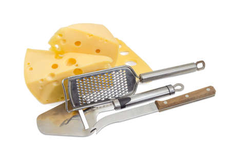 Cheese knife, cheese slicer, cheese grater against the background of the pieces semi-hard Swiss-type...