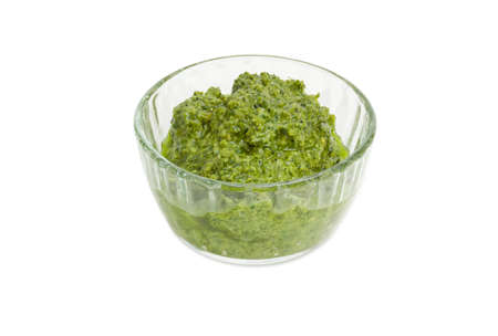 Sauce basil pesto in the small glass bowl on a white backgroundの写真素材