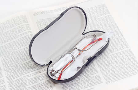 Modern classic men's eyeglasses in case on the open bookの写真素材