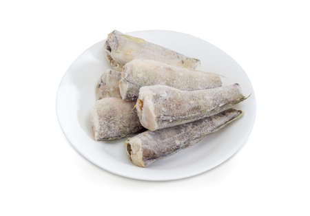 Several carcasses of the frozen saltwater fish notothenia without of a heads and tails on a white...