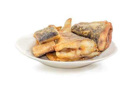 Several fried slices of carp on a white dish on a white background