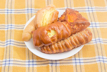 Different bakery products - bun, sausage roll and various pies stuffed with cottage cheese on a...