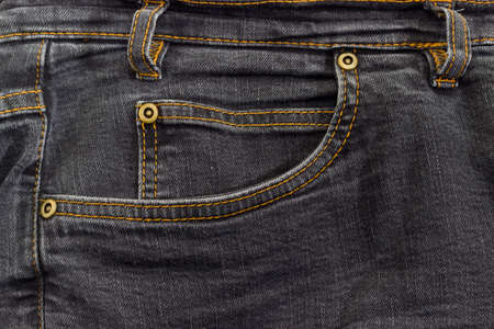 Fragment of the top of the used black jeans with waistband, belt loop, reinforcing by copper rivets pocket and little pocket の写真素材