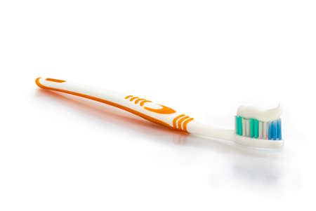 White and yellow toothbrush with toothpaste on white matte surface in bathroom
の写真素材