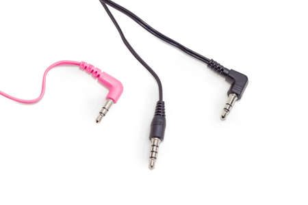 Red and black typical stereo audio plugs and black stereo plug for headset with fragments of the...