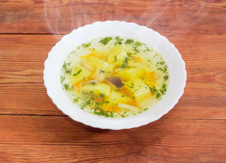 Hot mushroom soup made of fresh king oyster mushrooms in white bowl on the rustic wooden surfaceの写真素材