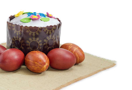 Fragment of the cloth napkin and Easter cake decorated with white icing and colorful sugar decors,...