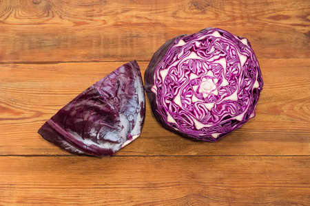 Two halves of head of the red cabbage on an old rustic table