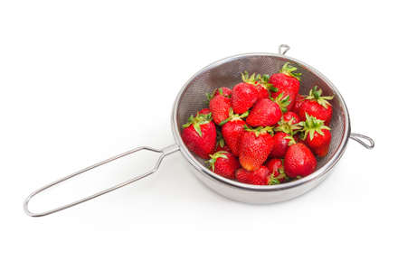 Fresh washed garden strawberries in stainless steel sieve on a white background 