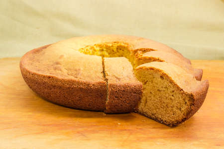 Partially sliced homemade ring shape cake with cylindrical hole in the center known as bundt cake...