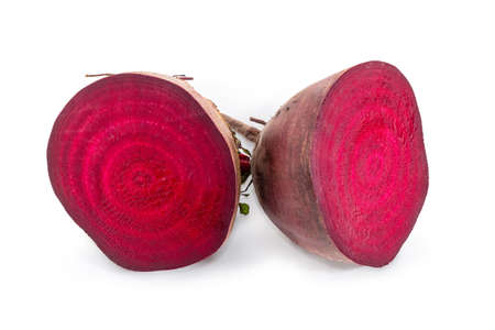 Two halves of the uncooked red beetroot bisected across on a white backgroundの写真素材