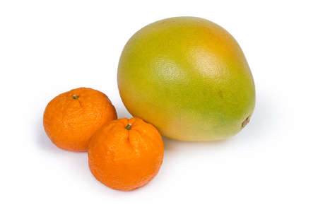 Whole ripe pomelo fruit and two mandarin oranges on a white backgroundの写真素材