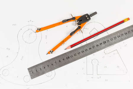 Top view of the pencil, ruler and drawing jointed pair of compasses on a training drawing