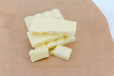 Pieces of the white aerated chocolate close-up on a wrapping-paper at selective focusの写真素材