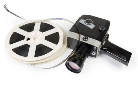 Old vintage amateur film movie camera powered by clockwork motor and reels of color motion picture films Super 8mm format on a white backgroundの写真素材