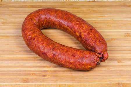 Boiled-smoked pork sausage known as bologna sausage in natural casing curtailed by a ring on the...