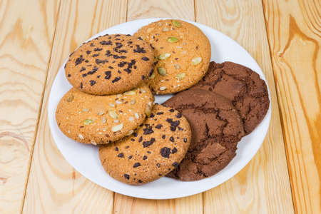 Chocolate chip cookie, cookie with chocolate dough and cookie sprinkled with different seeds on a...