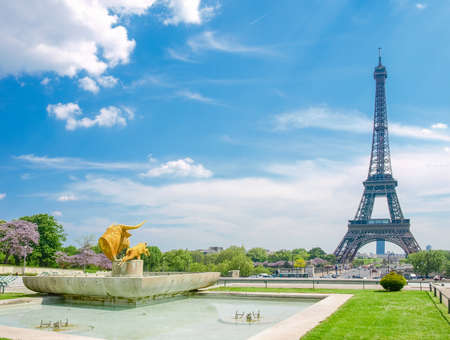 View of the Eiffel Tower from the Trocadero Square with fountain and sculptures in the foreground on the background the sky with clouds in Paris.の写真素材