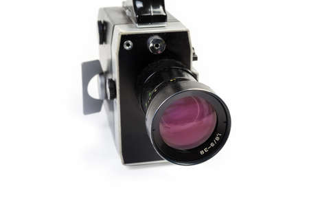 Old Super 8mm format amateur film movie camera powered by clockwork motor on a white background. View from the side of the lens close-up at selective focusの写真素材