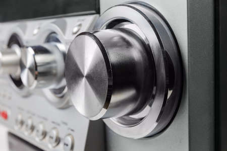 Fragment of the home stereo mini Hi-Fi music system with metal volume control knob on a foreground close-up at selective focusの写真素材