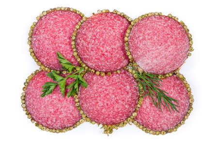 Thin slices of salami, coated with green peppercorns crust, decorated with dill and parsley twigs on...