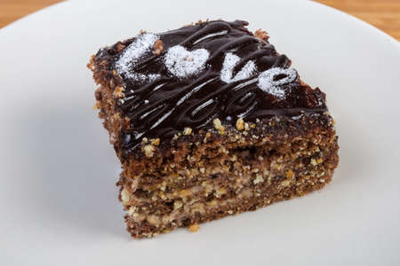 Slice of the layered sponge cake with chocolate coating and decoration with word LOVE made with...
