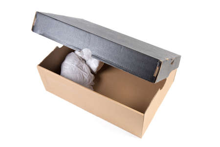 Brown cardboard shoes box with partly open black lid on a white background