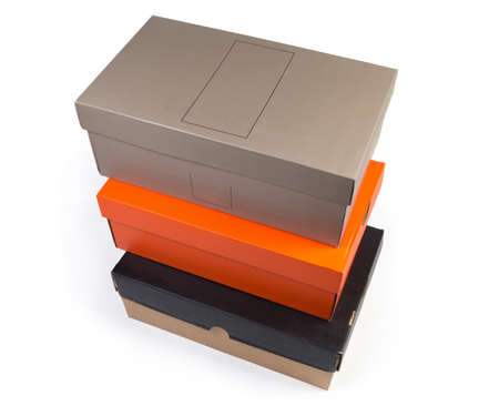 Different stacked closed cardboard shoes boxes various colors on a white background, top view