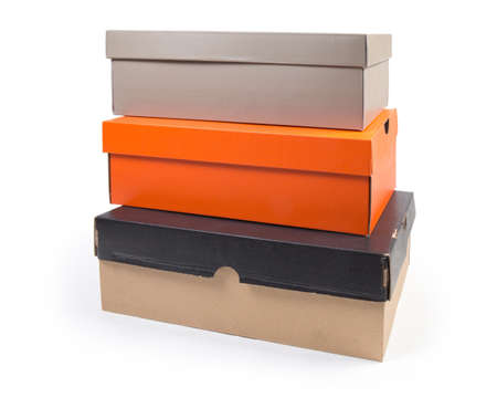 Stack of different closed cardboard shoes boxes various colors on a white backgroundの写真素材