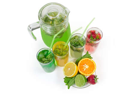 Cold drinks with various freshly squeezed citrus, strawberry and mint, jug with drink, mint twigs, strawberry and halves of citrus on a white background, top viewの写真素材