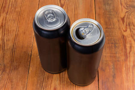 One open and one closed modern black beverage cans made of aluminum alloy on the rustic tableの写真素材