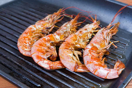 Grilled wild Argentinian red shrimps with heads on the grill pan close-up in selective focus
の写真素材