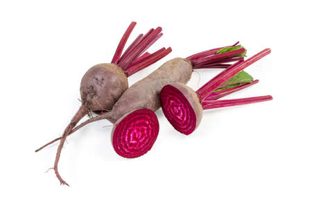 Raw whole young red beetroots different shape with part of the stems and two beetroot halves on a white backgroundの写真素材