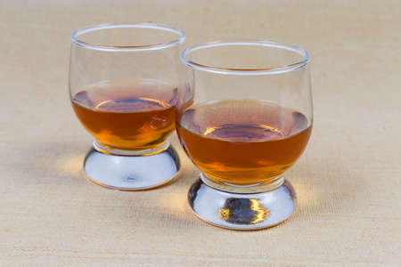 Two portions of brandy in brandy bowls on tablecloth closeup