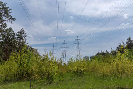 Three overhead power lines with transmission towers od the steel lattice structures among of the...
