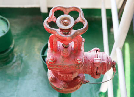 Old fire hydrant with water valve at the top part aboard river pleasure motor ship close-up in...