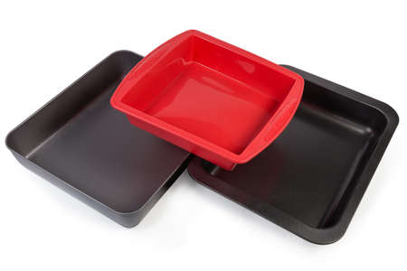 Two different empty rectangular metal oven trays with nonstick coating and silicone baking tray on a white backgroundの写真素材