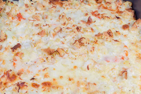 Browned crust of gratin made with cauliflower, shrimps, cheese and breadcrumbs close-up in selective focusの写真素材