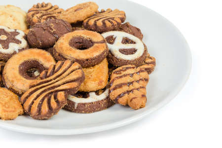 Shortbread cookies different shapes, covered with various coating and icing on dish on a white...