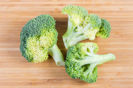 Small branches with inflorescences of the fresh broccoli close-up on the bamboo cutting board, top viewの写真素材