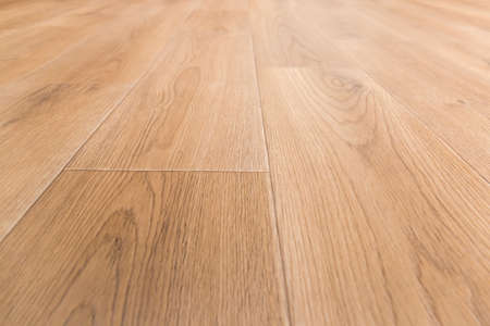 Linoleum flooring with embossed imitation of wooden planks pattern, fragment, low point view in selective focus
の写真素材