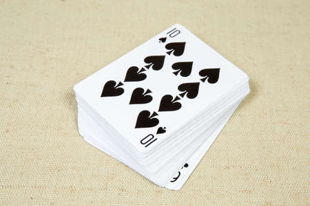 Face-up standard deck of French playing cards on the cloth surface close-up in selective focus